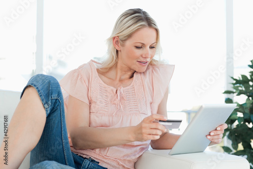 Photo: Blonde woman buying online with a touchpad Blonde woman buying online with a touchpad