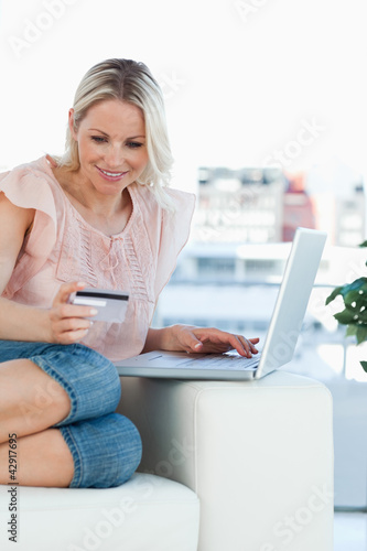 Photo: Blonde buying online on a laptop Blonde buying online on a laptop