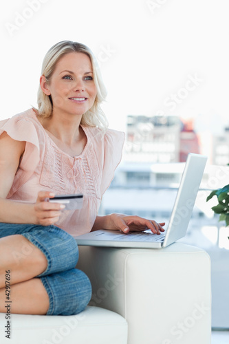 Photo: Blonde shopping online with a laptop Blonde shopping online with a laptop