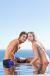 Couple enjoying their time together on the swimming pool edge