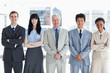 Photo: Five members of a business team standing upright while smiling Five members of a business team standing upright while smiling