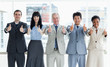 Photo: Smiling business people showing their approval with their thumbs up Smiling business people showing their approval with their thumbs up