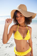 Photo: Young beautiful woman standing up with puckered lips while holding her hat brim Young beautiful woman standing up with puckered lips while holding her hat brim