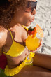 Young attractive woman in beachwear sipping a fruit cocktail