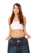 Young beautiful woman is showing too big trousers.