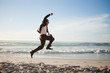 Successful businessman jumping on the beach