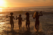 Four young women walking in the water together