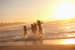 Young happy women dancing in the water at sunset