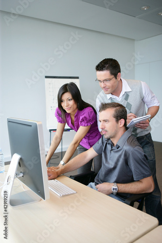 Foto: Dynamic trio working at a desktop computer Dynamic trio working at a desktop computer