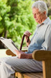 Old man sitting down reading a newspaper 