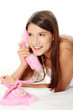 Young beautiful girl is talking by pink phone.