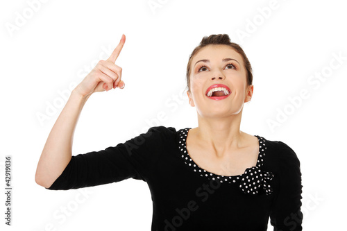Photo: Beautiful woman is laughing and pointing up. Beautiful woman is laughing and pointing up.