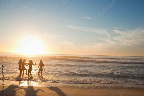 Photo: Four women wading in the water Four women wading in the water