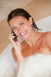 Photo: Smiling woman with her cellphone in the tub Smiling woman with her cellphone in the tub