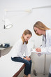 Doctor writing on a notepad what a girl tells to her