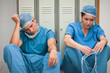 Two sad surgeons sitting in a locker room