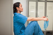 Thinking female surgeon sitting in a locker room