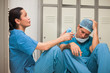 Two thinking surgeons sitting in a locker room