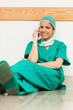 Surgeon happy while sitting on the floor and phoning