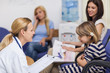 Female doctor talking to a girl in a waiting room