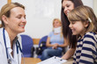 Doctor and girl smiling while sitting in a waiting room