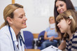 General practitioner talking to a girl in a waiting room