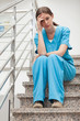 Thinking woman sitting on stairs
