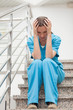 Nurse holding her head with her two hands in stairs