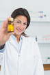 Smiling female pharmacist presenting pills and standing in a pharmacy
