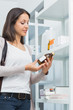 Customer in a pharmacy holding a bottle of drug