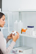 Woman looking at a box of pills