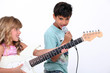 Two children singing and playing guitar