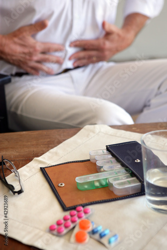 Foto: Man with stomach ache and pills Man with stomach ache and pills