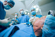 Surgery team in an operating theater operating an unconscious patient