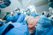 Surgerical team in an operating theater operating an unconscious patient