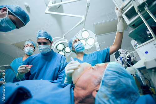 Photo: Surgical team in an operating theater operating a patient Surgical team in an operating theater operating a patient