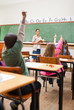 Back view of elementary school students rising hands