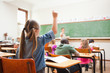 Back view of primary school student raising hand