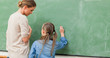 Photo : Teacher and pupil next to blackboard Teacher and pupil next to blackboard
