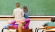 Photo : Back view of teacher and pupil writing on blackboard Back view of teacher and pupil writing on blackboard