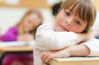 Girl leaning on her desk with arms crossed