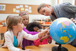 Teacher explaining globe to her students