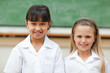 Smiling girls in front of blackboard