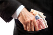 Businessman putting money in his pocket.