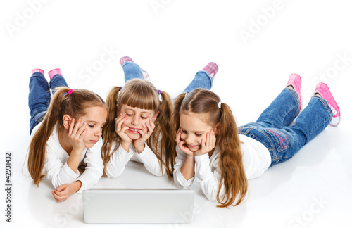 Photo: Three attractive girl using a laptop Three attractive girl using a laptop