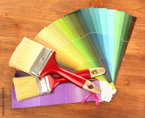Photo: paint brushes and bright palette of colors on wooden background paint brushes and bright palette of colors on wooden background