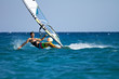 Young man surfing the wind in splashes of water