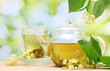 teapot and cup with linden tea  and flowers