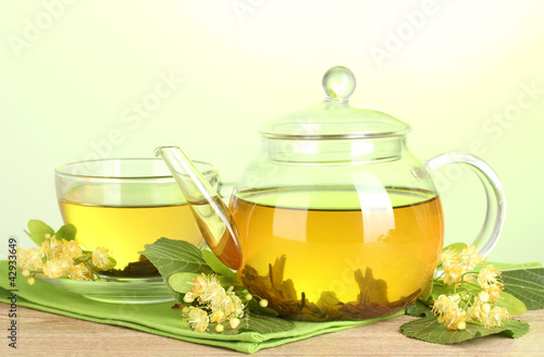 Photo: teapot and cup with linden tea and flowers teapot and cup with linden tea and flowers