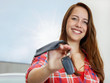 Foto: Pretty woman proudly presents the key of her new car Pretty woman proudly presents the key of her new car
